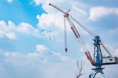 İnşaat alanındaki vinç ve mavi gökyüzü hakkında. Kule vincini vurguluyor.