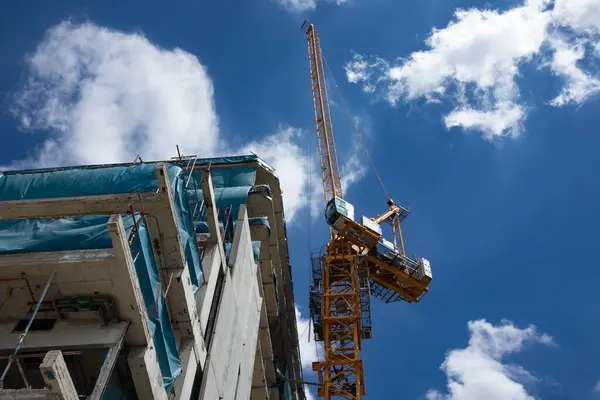 stock image about the tower crane at the construction site and blue sky by emphasizing the tower crane