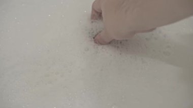 İnsanlar su boşaltma tıpasını kapatır ve küveti sıcak su ve kalın köpükle doldurur. Hijyenik prosedür. Rahatlatıcı köpük banyosu. Cesetle ilgilenmek için kozmetik ürün ekliyorum..