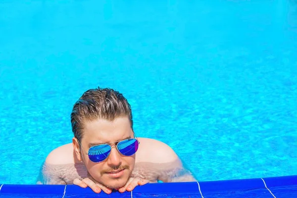 Man swimming in the pool. Man in pool having fun on summer holidays. Young man swimming and lurking on vacation.