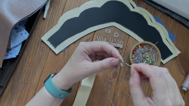 ニードルウーマンは スレッドとスラブ民族のヘアアクセサリーのための針で革布の部分を縫います 木のテーブルの縫製プロセスのトップビュー 趣味や工芸品について — ストック動画