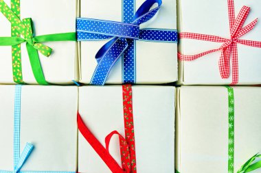 Bir yığın hediye paketlenmiş Noel hediyeleri. Kutular düzgünce masanın üzerine istiflenmiş. Yukarıdan görüntüle.