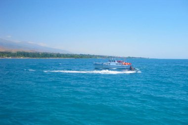 Güneşli bir günde, küçük bir motorlu geminin handikapında, denizde jet ski.