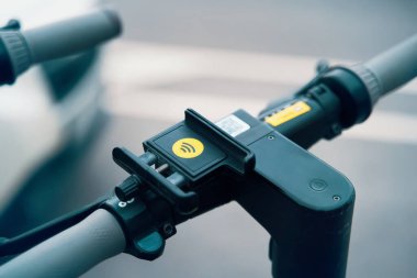 Mobiletlerin gidonuna monte edilmiş, pratik ve uygun bir bisiklet parçası gösteren bir telefon tutucunun yakın çekimi. Bu kullanışlı araç hareket halindeyken telefonunuzu güvenli bir şekilde tutmak için mükemmeldir.