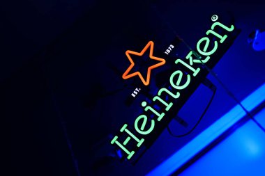 Bardaki mavi ışıklı arka planlı barda Heineken neon tabelaları. BISHKEK, KYRGYZ Cumhuriyet - 25 HAZİRAN 2021