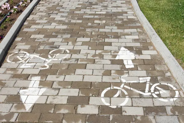 stock image A brick walkway adorned with bicycle and arrow designs, enhancing the urban design with a unique twist. The combination of wood and brickwork creates a rustic yet modern flooring experience