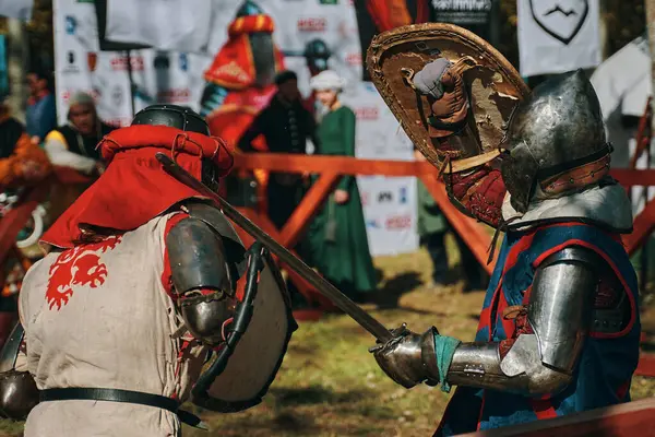 Ortaçağ mızrak dövüşlerinin yeniden yapılandırılması. Arenadaki farklı tarihsel kulüplerden iki şövalyenin savaşı. Kılıç dövüşü. Bishkek, Kırgızistan - 13 Ekim 2019