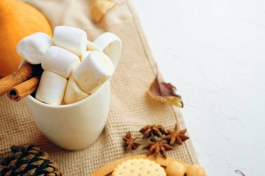 Sıcak sonbahar sahnesi, sıcak çikolata, marşmelov, baharatlar, yapraklar ve rahat süveter. Mevsimsel içerik için mükemmel.