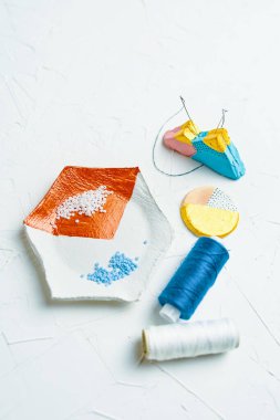 Masadaki boncuk ve ipliklerle mücevher oluşturma süreci