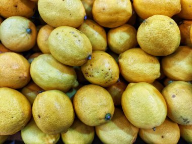 Bir yığın canlı sarı limon düzgünce dizilmiş.