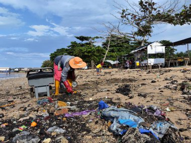 Balikpapan-Doğu Borneo 17 Ağustos 2024 hademeler bir sürü çöpü olan plajı temizliyorlar.