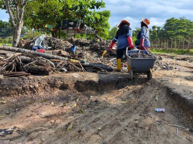 Balikpapan-Doğu Borneo 17 Ağustos 2024 hademeler bir sürü çöpü olan plajı temizliyorlar.