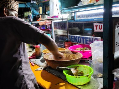 Balikpapan-Doğu Borneo 16 Ağustos 2024, Tahu Tek satıcı bir müşteriye hizmet ediyor. Doğu Java 'dan özel bir yemek. İçinde tofu, fasulye filizi, pirinç keki, turşu, omlet, fıstık sosu ve petis var.