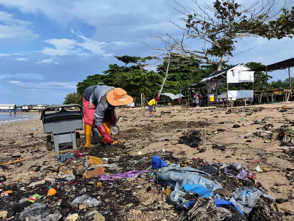 Balikpapan-Doğu Borneo 17 Ağustos 2024 hademeler bir sürü çöpü olan plajı temizliyorlar.