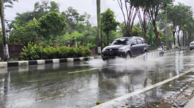 Balikpapan-Doğu Borneo 18 Ağustos 2024, asfalt ıslak yolda yağmurda araba sürmek