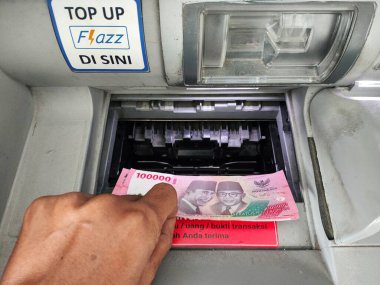 Endonezya-Balikpapan-Endonezya 26 Ağustos 2024, Endonezya 'daki ATM' den para çeken kişi. El para alıyor.