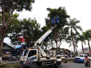 Balikpapan-Endonezya 30 Ağustos 2024 Elektrik işçisi vinç tamir kovası sokak ışıklandırmasında 