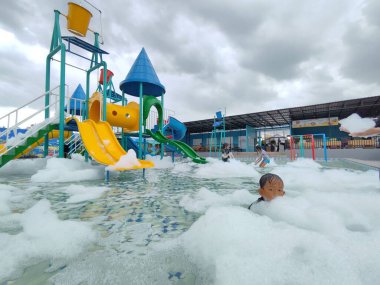 Balikpapan-Indonesia March 16th,2024 Children Playground with Colorful Slider in Swimming Pool Aquapark and filled with foam clipart