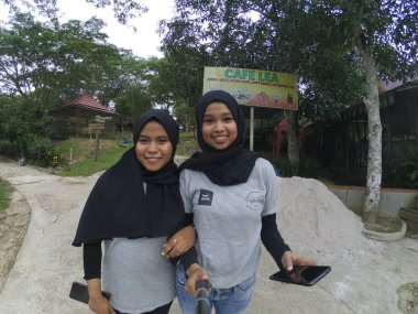 Balikpapan-Doğu Kalimantan 25 Kasım 2020 Mutlu gülümseyen Asyalı tesettürlü iki genç kızın selfie 'si