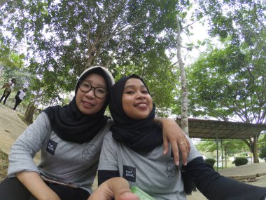 Balikpapan-Doğu Kalimantan 25 Kasım 2020 Mutlu gülümseyen Asyalı tesettürlü iki genç kızın selfie 'si