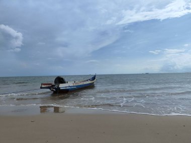  Kıyıda balıkçı tekneleri olan güzel, temiz, beyaz kumlu bir kumsal..