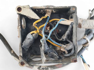 Kutudaki kirli elektrik kabloları beyaz arka planda izole edilmiş dağınık görünüyor.