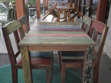 Balikpapan-Doğu Kalimantan Kasım 02.2024 Kapalı bir açık kafe terası ahşap masalar ve sandalyeler düzgünce dizilmiş, güneşli bir günde Hitam Manis Kafe 'de müşterileri bekliyor.