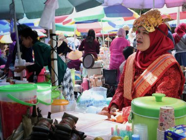 Balikpapan doğusundaki Kalimantan Kasım 03.2024 Endonezyalı kadın gıda satıcısı geleneksel Balikpapan pazarında alıcılara hizmet veriyor