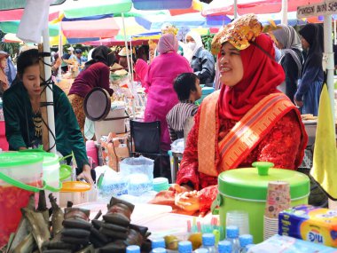 Balikpapan doğusundaki Kalimantan Kasım 03.2024 Endonezyalı kadın gıda satıcısı geleneksel Balikpapan pazarında alıcılara hizmet veriyor