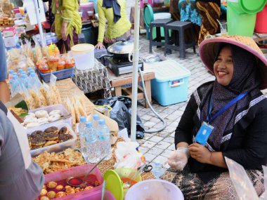 Balikpapan doğusundaki Kalimantan Kasım 03.2024 Endonezyalı kadın gıda satıcısı geleneksel Balikpapan pazarında alıcılara hizmet veriyor