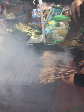 Balikpapan doğusundaki Kalimantan Kasım 03.2024 Izgara satay ya da sıcak kömür üzerine doymuş dumanla çevrili geleneksel sokak yiyeceklerinin otantik hazırlama sürecini gözler önüne seriyor.