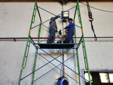 Balikpapan-East Kalimantan November 11,2024 Two people working at height on scaffolding without PPE and safety harness clipart