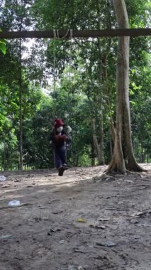 Balikpapan-Doğu Kalimantan Kasım 23. 2024 Çocuk açık hava oyun sahasında oynuyor. Çocuklar okulda ya da anaokulunda oynarlar. Renkli salıncaktaki aktif çocuk.. 