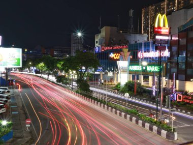 Balikpapan-Doğu Kalimantan Kasım 07.2024, Balikpapan Plaza 'nın önündeki yaya köprüsündeki araçlardan gelen hafif patika. Burası gece fotoğrafçılığının ve uzun pozların favori mekanıdır.