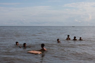 Balikpapan-Endonezya 12 Aralık 2024 Denizde yüzen arkadaş grubu - Denizde eğlenen çok ahlaklı bir grup