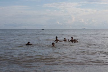 Balikpapan-Endonezya 12 Aralık 2024 Denizde yüzen arkadaş grubu - Denizde eğlenen çok ahlaklı bir grup