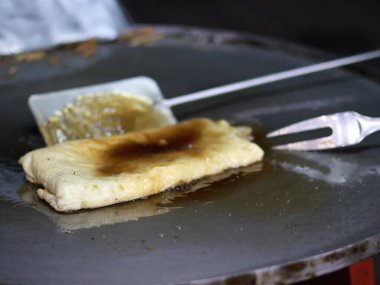 Bir Martabak Telur yapma ya da pişirme süreci. Tavada sıcak yağ ile kızartılan aperatifler yumurta, et, sebze ve baharatla dolu undan yapılır..
