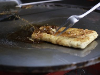 Bir Martabak Telur yapma ya da pişirme süreci. Tavada sıcak yağ ile kızartılan aperatifler yumurta, et, sebze ve baharatla dolu undan yapılır..