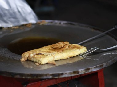 Bir Martabak Telur yapma ya da pişirme süreci. Tavada sıcak yağ ile kızartılan aperatifler yumurta, et, sebze ve baharatla dolu undan yapılır..