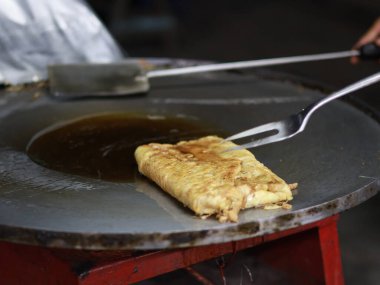 Bir Martabak Telur yapma ya da pişirme süreci. Tavada sıcak yağ ile kızartılan aperatifler yumurta, et, sebze ve baharatla dolu undan yapılır..