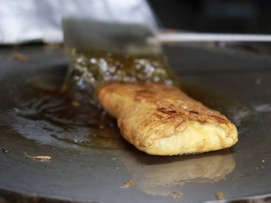 Bir Martabak Telur yapma ya da pişirme süreci. Tavada sıcak yağ ile kızartılan aperatifler yumurta, et, sebze ve baharatla dolu undan yapılır..