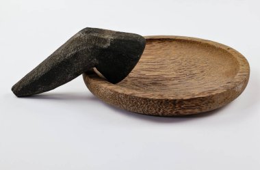 Beyaz üzerine izole edilmiş, ahşap bir havan ve taş tokmağın yakın plan görüntüsü.