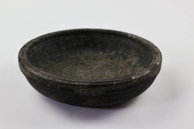 Beyaz üzerine izole edilmiş bir taş havan. Baharat ve diğer yemek malzemelerini öğütmek için kullanılan geleneksel bir mutfak aleti. Bu havan topu koyu gri doğal taştan yapılmıştır..