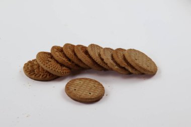 BISCUITS - Bir yığın lezzetli buğday yuvarlak bisküvi beyaz arka planda birkaç kırıntı, lezzetli gevrek yuvarlak krakerler