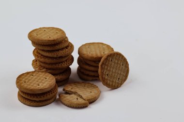 BISCUITS - Bir yığın lezzetli buğday yuvarlak bisküvi beyaz arka planda birkaç kırıntı, lezzetli gevrek yuvarlak krakerler