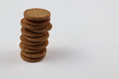 BISCUITS - Bir yığın lezzetli buğday yuvarlak bisküvi beyaz arka planda birkaç kırıntı, lezzetli gevrek yuvarlak krakerler