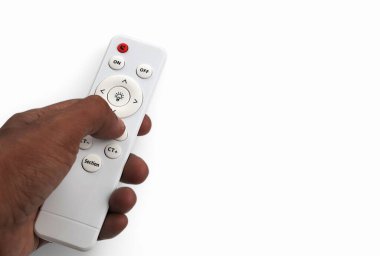 Uzaktan kumandayı tutan ve beyaz arkaplanda izole edilmiş düğmeye basan