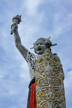Balikpapan-Endonezya 14 Şubat 2025 Balikpapan şehrinden izole edilmiş mavi gökyüzüne sahip bir Dayak heykeli