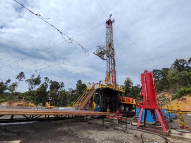 Bunyu Adası-Kuzey Borneo Nisan 1,2025 Endonezya, petrol ve gaz sondaj platformunda dramatik bulutlu tatlı sondajı. Kara petrol sondajı mavi gökyüzü.
