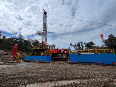 Bunyu Adası-Kuzey Borneo Nisan 1,2025 Endonezya, petrol ve gaz sondaj platformunda dramatik bulutlu tatlı sondajı. Kara petrol sondajı mavi gökyüzü.